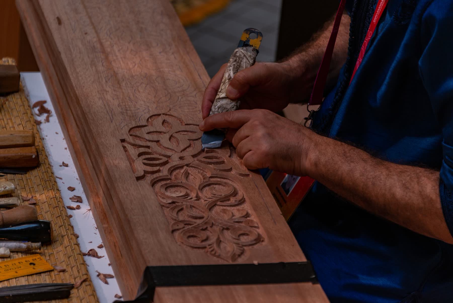 Hands carving a wood panel