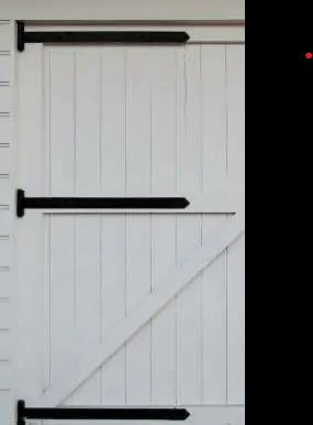 Black strap hinge on a white board door